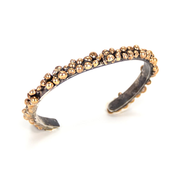 Nature inspired with organic styling on a simple oxidized silver cuff with a bronze seed-like nodules.